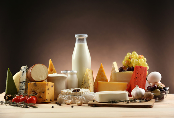 Tasty dairy products on wooden table, on dark background - Zdjęcie, obraz