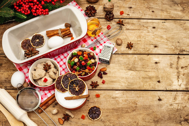Hintergrund der Weihnachtsbäckerei ist 2021. Traditioneller sächsischer Stollen mit Früchten und Nüssen. Zutaten für das Kochen im neuen Jahr. Festliches Dekor, Holzbretter, Draufsicht - Foto, Bild