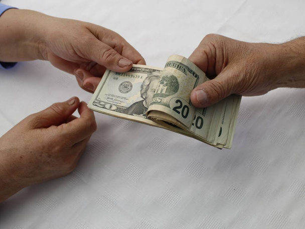 mani che pagano e ricevono banconote in dollari americani - Foto, immagini