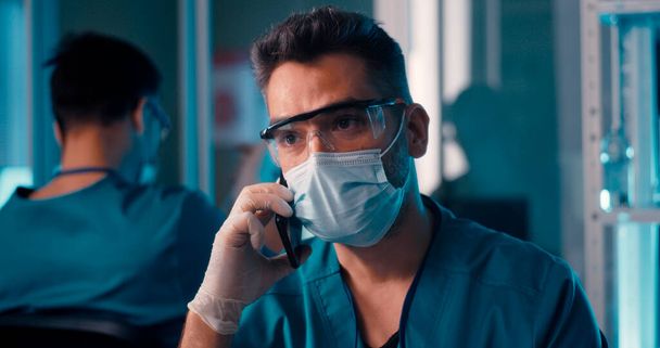 Médecin masculin parlant sur smartphone en laboratoire - Photo, image
