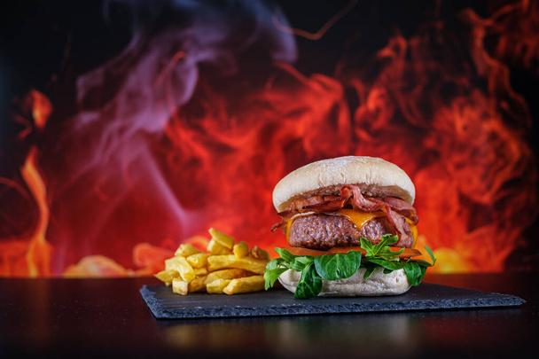 Hamburger mit Pommes mit Feuer Hintergrund - Foto, Bild