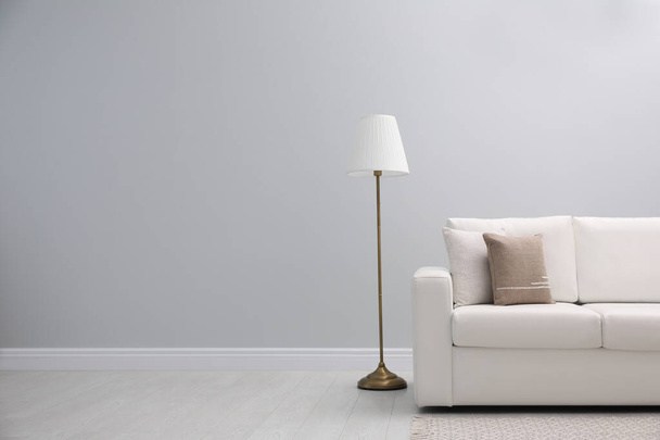 Simple room interior with comfortable white sofa, space for text - Zdjęcie, obraz