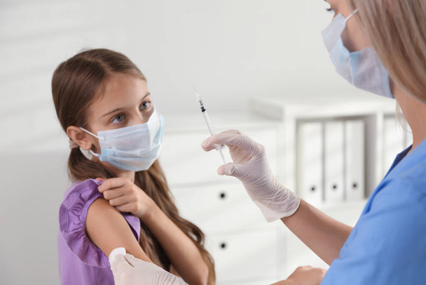 Doctor vaccinating little girl in hospital. Health care - Photo, image