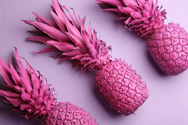 Pink pineapples on light background, flat lay. Creative concept - Foto, Imagen