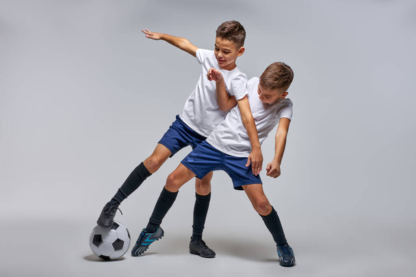 two boys playing soccer, enjoying sports game - Photo, image