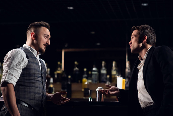 двоє чоловіків друзів зустрічаються в барі за стійкою і спілкуються
 - Фото, зображення