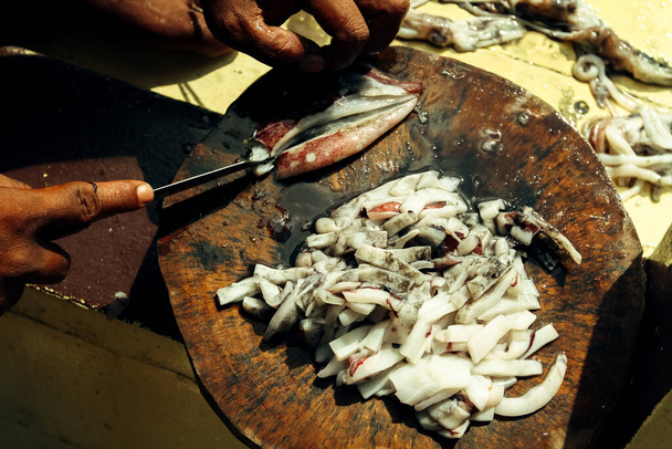 Tayland Körfezi 'nde mürekkep balığı yemi. Eller yakın planda parçalanıyor.. - Fotoğraf, Görsel
