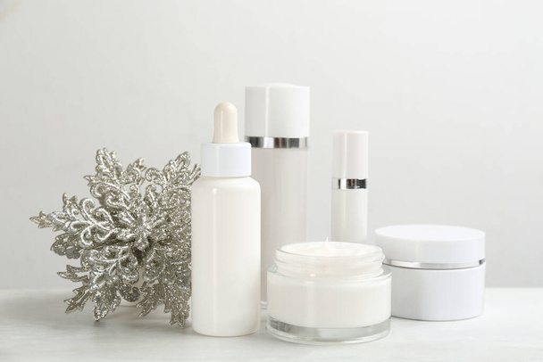 Beautiful composition with different cosmetic products on white table. Winter care - Фото, изображение