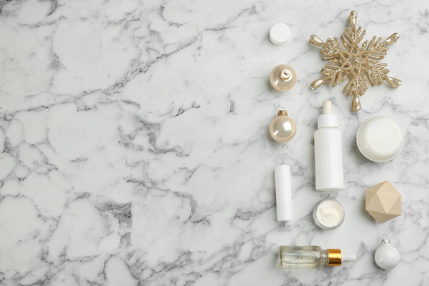 Flat lay composition with different cosmetic products on white marble table, space for text. Winter care - Photo, Image