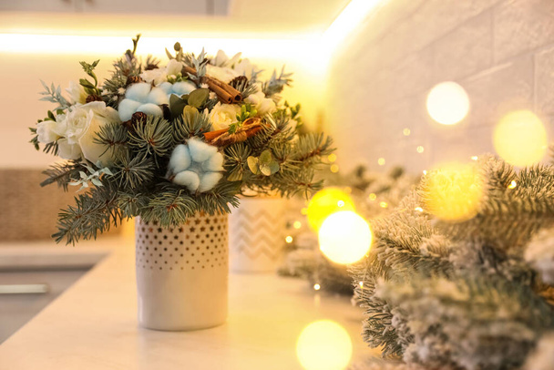 Beautiful winter bouquet and fir tree branches on white table indoors - Foto, Imagen