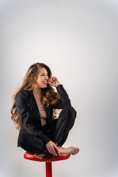 A beautiful mixed race model poses in a business suit in a studio environment - Fotografie, Obrázek