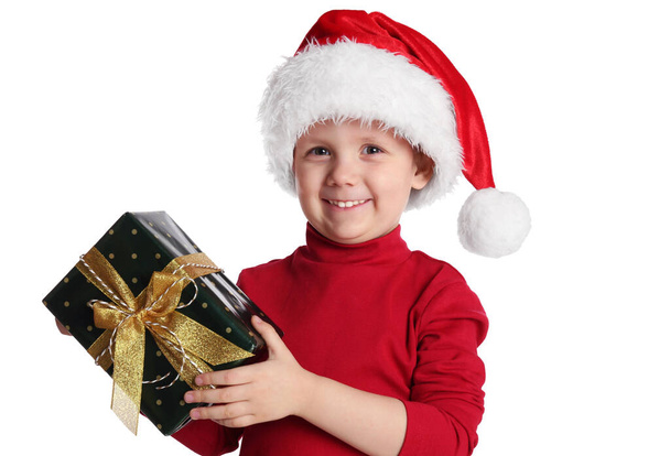 Cute child in Santa hat with Christmas gift on white background - Foto, Imagem