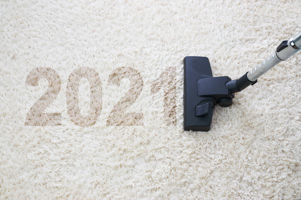 Καθαρισμός σπιτιού με ηλεκτρική σκούπα και αντιγραφή χώρου για κείμενο, νέο έτος 2021 - Φωτογραφία, εικόνα