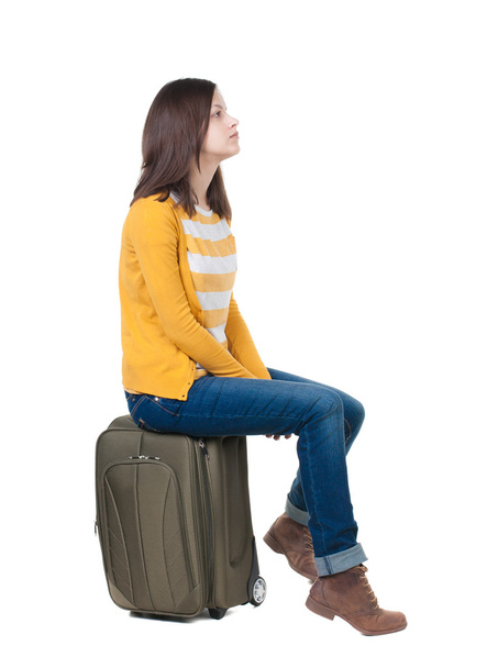 Woman sits on a suitcase - Φωτογραφία, εικόνα