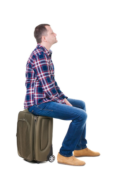 Man sitting on a suitcase - Фото, изображение