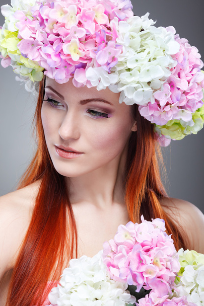 Close-up portrait of beautiful young redheaded girl in a chaplet with  flowers - Valokuva, kuva