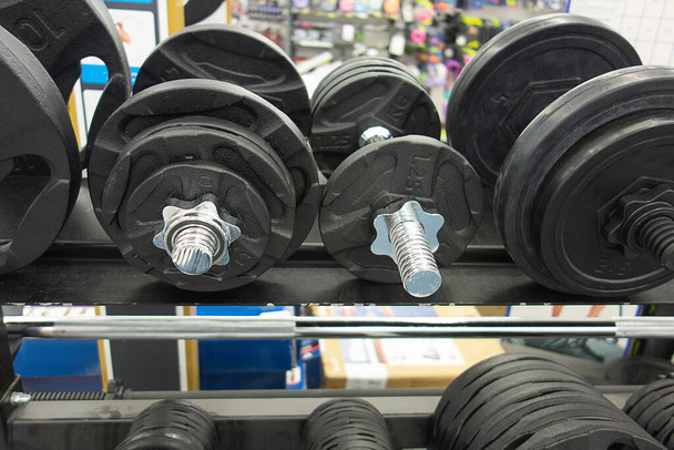 different weights from the bar and dumbbells in the sports store. sports concept. copy space. - Photo, Image