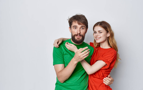 cheerful man and woman multicolored t-shirts embrace friendship emotions lifestyle - Photo, image