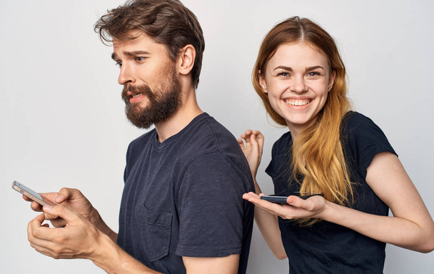 veselý mladý pár s telefony v ruce technologie emoce Studio - Fotografie, Obrázek