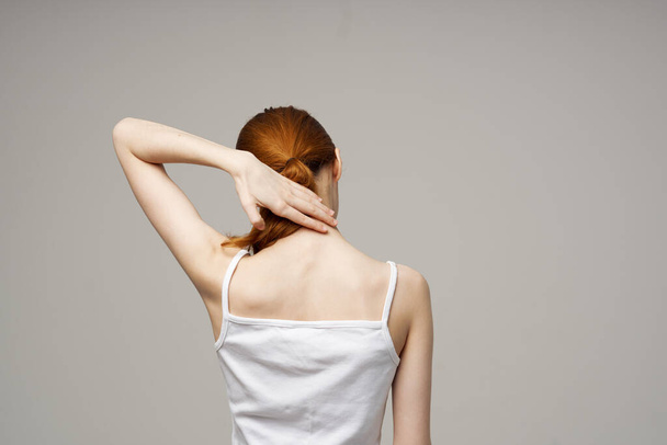 mujer camiseta toca su espalda con las manos hacia atrás ver Copiar espacio - Foto, imagen