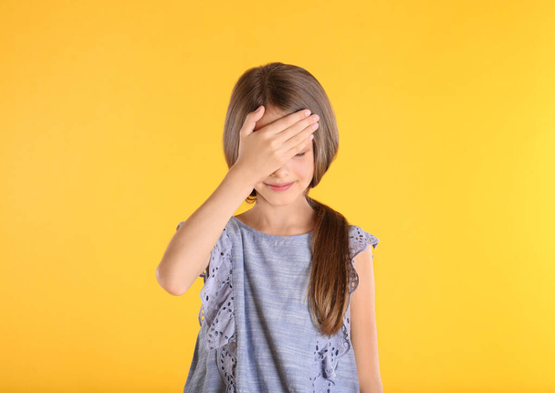 Portrait of emotional little girl on yellow background - 写真・画像