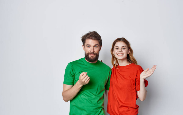 cheerful man and woman multicolored t-shirts embrace friendship emotions lifestyle - Photo, Image