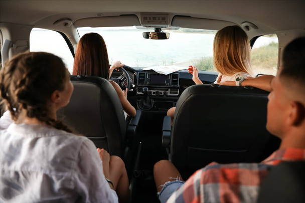 Happy friends together in car on road trip - Photo, Image