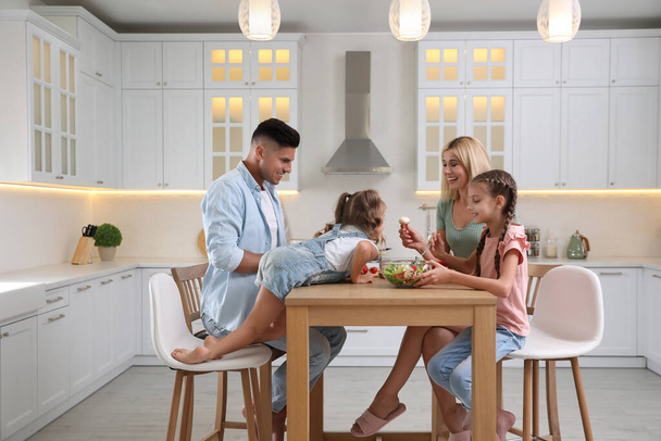 Happy family cooking together at table in modern kitchen - Фото, зображення