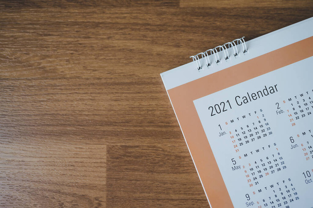 Draufsicht mit Kalender 2021 Monat auf Holz, Terminvereinbarung oder Tagesablauf für die Planung von Arbeit und Lebenskonzept - Foto, Bild