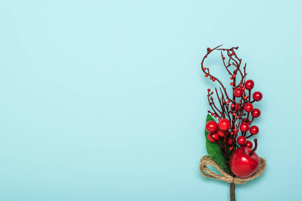 Decoration of a twig with red apples on a blue background. New year's eve. - Fotoğraf, Görsel