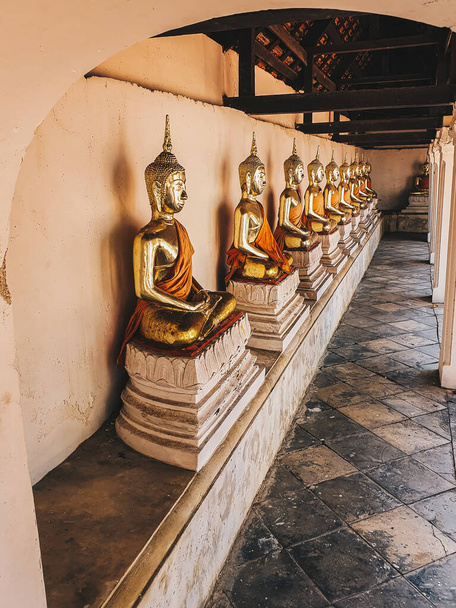 Row of golden peaceful sitting buddha statue in the Thailand temple - Foto, immagini