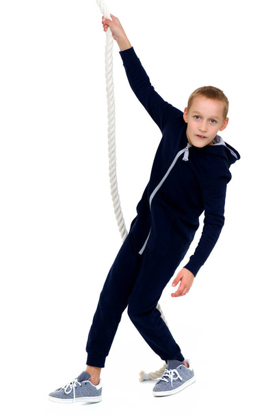 Actieve lachende jongen opknoping op swing touw - Foto, afbeelding
