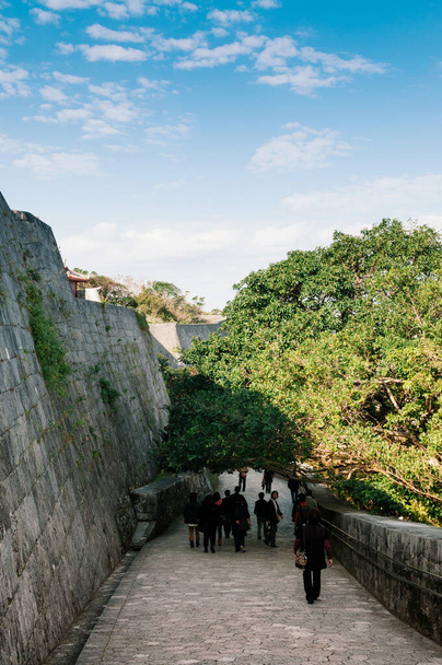 Старий мур і фортеця Шури під чистим синім небом з туристами, Нага, Окінава, Японія. - Фото, зображення