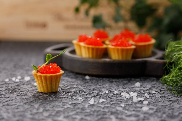 Appetizing tartlets with red caviar and microgreen decor. Holiday concept. - Foto, Bild