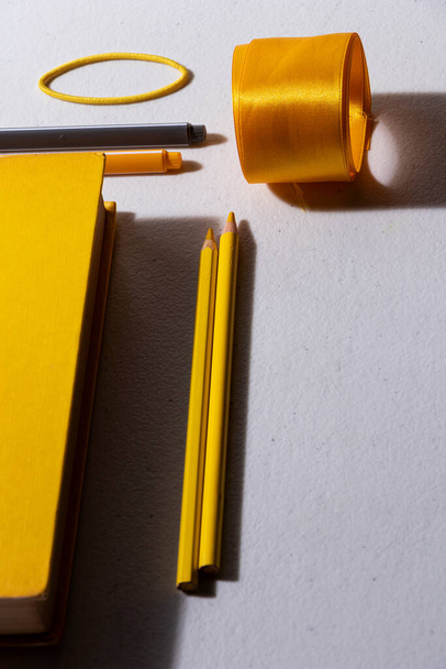 黄色の表紙本の白いテーブルの上に他の項目と黄色の鉛筆弾丸ジャーナルを作るために - 写真・画像