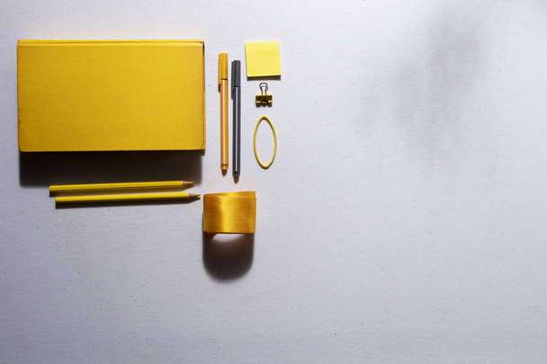 Mesa branca com clipes de lápis coloridos, fitas e adesivos amarelos para construir um diário de bala e objetos cinza final - Foto, Imagem