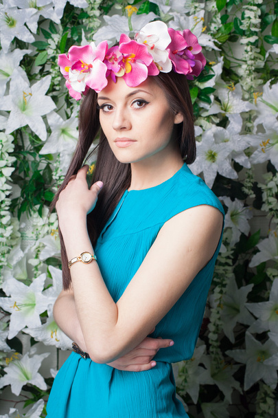 Beautiful and fashion young woman near the wall of flowers - Zdjęcie, obraz