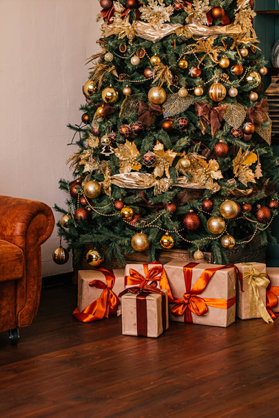 Cadeaudoosjes en gouden kerstboom, ingepakte cadeautjes en decor in landelijke stijl als vakantiehuisdecoratie - Foto, afbeelding