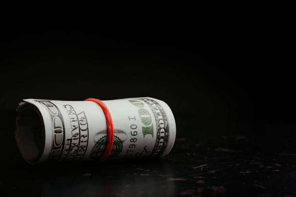 Money roll dollars on the black background - Фото, изображение