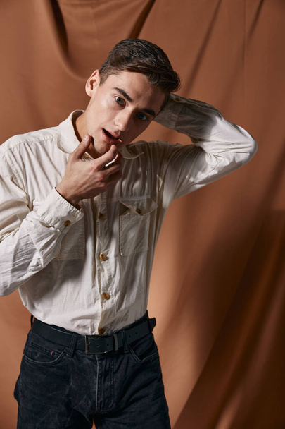 Um homem com uma camisa branca segura as mãos perto de sua cabeça modelo de auto-confiança estilo moderno - Foto, Imagem