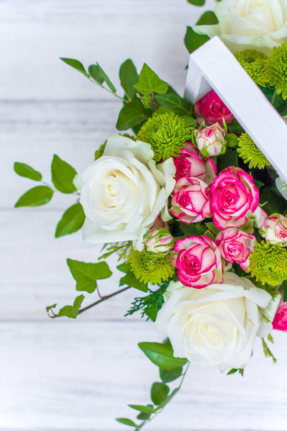 Wooden box with white and pink roses and chrysanthemums on  white wooden board. Decoration of home. Flowers boxes. Wedding decoration - Foto, afbeelding