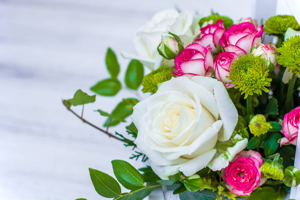 Dřevěná krabice s bílými a růžovými růžemi a chryzantémama na bílém dřevěném prkně. Dekorace domova. Krabice s květinami. Svatební dekorace - Fotografie, Obrázek