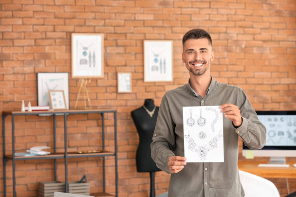 Male jewelry designer with sketches in office - Foto, afbeelding
