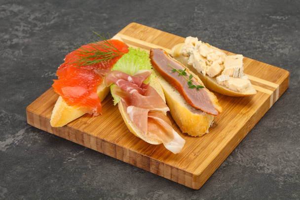 Tapas - bruschetta with prosciutto, salmon, duck and gorgonzola cheese - Zdjęcie, obraz