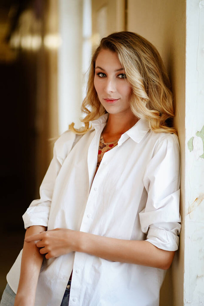 beautiful young woman with long blonde hair in a white mens shirt. - Foto, Imagem
