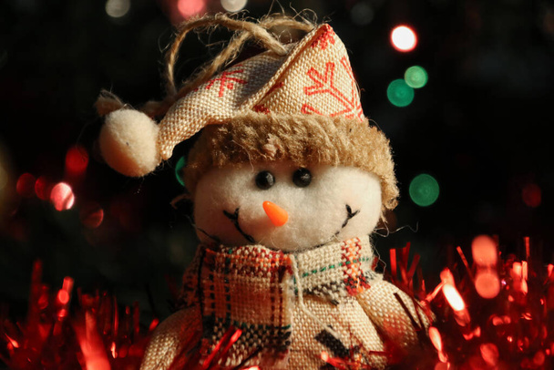 Concepto navideño con muchas luces, colores, guirnaldas y un juguete navideño hecho a mano - Foto, imagen