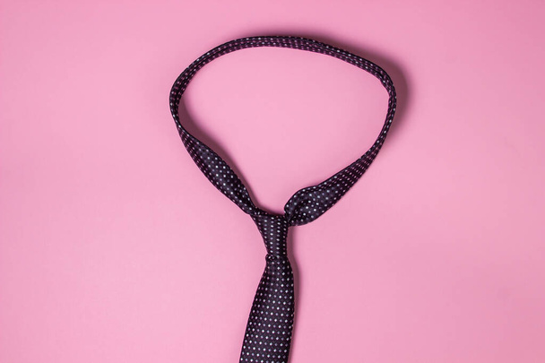 Fekete férfi nyakkendő. Rózsaszín háttér. Férfi módra. Klasszikus férfi divat. - Fotó, kép