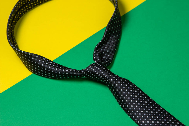 Schwarze Herrenkrawatte. Krawatte auf einem geometrischen Hintergrund. Männlicher Stil. Klassische Männermode - Foto, Bild