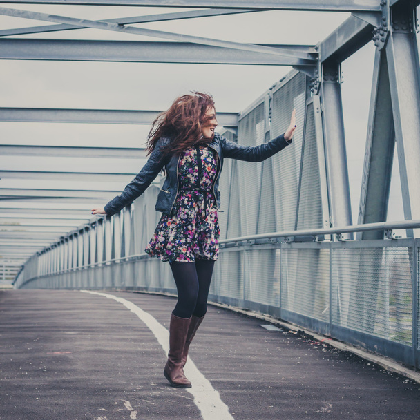 Pretty girl walking happy on a bridge - Foto, imagen