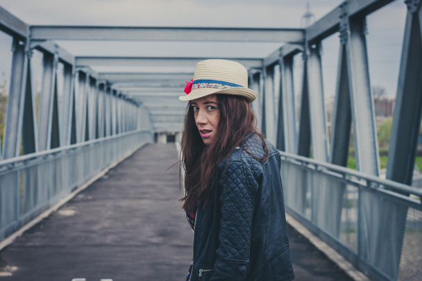 Pretty girl walking away on a bridge - Foto, afbeelding